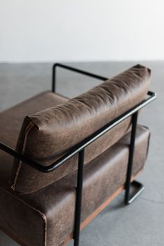 a brown leather couch sitting on top of a metal frame