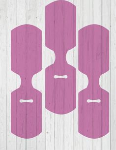 three pink shapes on white wooden planks