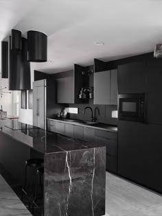 a black and white kitchen with marble counter tops