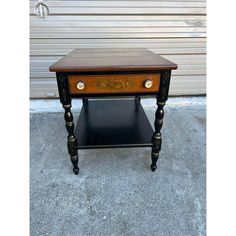 a small wooden table sitting on top of a cement floor next to a garage door