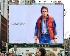 a large billboard with a man on it's side in the middle of a city