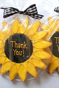 sunflower cookies with thank you written on them in plastic wrappers and tied to bows