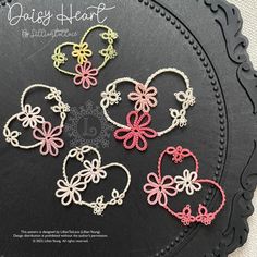 six heart shaped crochet patterns sitting on top of a black plate with the words daisy heart written in it