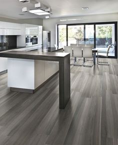 a modern kitchen with white cabinets and wood flooring