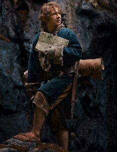 a man dressed in medieval clothing standing on rocks