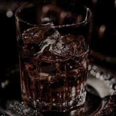 a glass filled with ice sitting on top of a plate