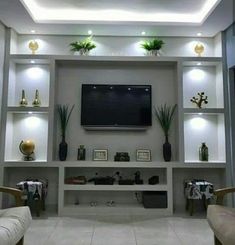 a living room filled with furniture and a flat screen tv mounted to the wall above it