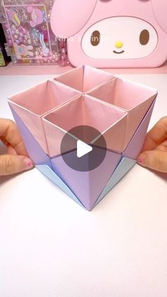 someone is holding an origami box in their hands with the video below it