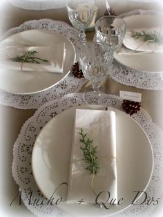 the table is set with white plates and place settings