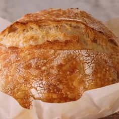 a loaf of bread sitting on top of a table next to some waxed paper