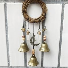 three bells hanging from the side of a wall next to a wreath and a door