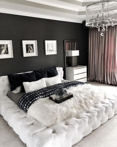 a white bed sitting in a bedroom under a chandelier