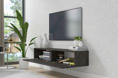 a living room with a large flat screen tv mounted on the wall above a book shelf