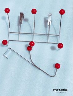 a metal rack with red balls on it and two forks sticking out of the top