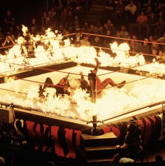 a wrestling match with flames in the ring