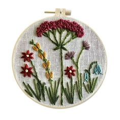 a cross stitch pattern with flowers in the hoop on a white wall hanging ornament