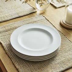 a stack of white plates sitting on top of a wooden table