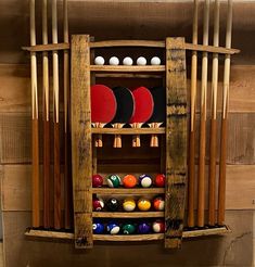 a rack full of ping pong balls and paddles in front of a wooden wall