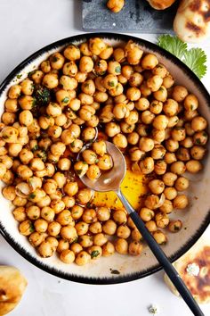 a bowl filled with chickpeas next to some bread