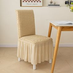 a chair that is sitting in front of a table with a flower vase on it