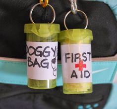 two first aid bottles are attached to a backpack strap that says doggy bag and first aid