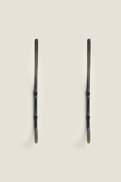 two black metal handles on a white surface