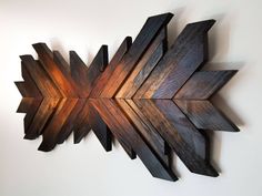 a wooden wall hanging with an arrow design on it