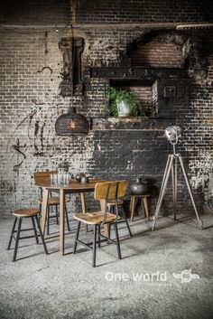 an old brick wall has been converted into a dining room with wooden chairs and tables