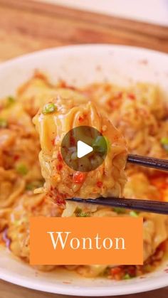 a bowl filled with noodles and chopsticks on top of a wooden table next to an orange sign that says wonton