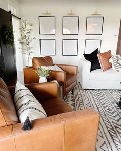 a living room with leather furniture and pictures on the wall above it's couches