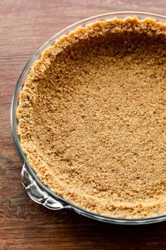 a pie crust in a glass dish on a wooden table