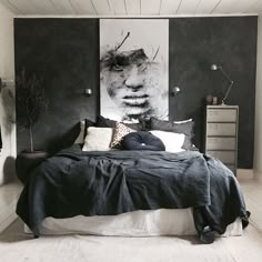 a black and white bedroom with a large painting on the wall