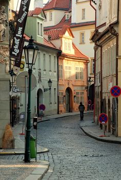 a cobblestone street in an old european city with lots of buildings on both sides