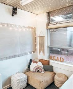 a living room with a couch, ottoman and large window