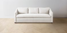 a white couch sitting on top of a hard wood floor