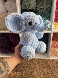 a hand holding an elephant made out of yarn