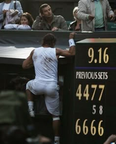 a tennis player leaning against the wall with his racket