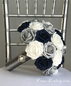 a bridal bouquet with blue and white flowers on top of a silver metal chair