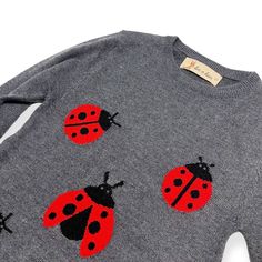 a sweater with red and black ladybugs on it