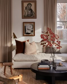 a living room filled with furniture and pictures on the wall above it's coffee table