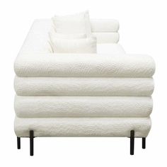 a stack of white towels sitting on top of each other in front of a couch