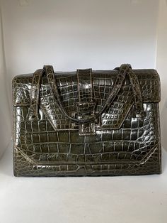 "Look at the exquisite craftsmanship and sophisticated design of this elegant 1950s alligator belly skin handbag by vintage designer LUCILLE de PARIS! Deep forest green color could almost pass for black. Classic double strap handbag with exterior flap front, crafted from gorgeous, perfectly symmetrical glossy belly skins. Exterior is in very good condition with some signs light wear and tear to straps. Very clean interior is genuine leather with zippered pocket, snap closure flap pocket and two Alligator Logo, Alligator Handbags, Structured Handbags, American Alligator, Deep Forest Green, Handbag Vintage, Forest Green Color, Princess Margaret, Top Handle Bags