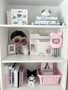 a white book shelf filled with lots of books and stuffed animals on top of it