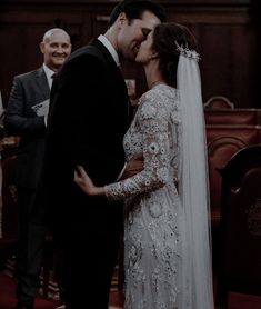 a bride and groom kissing in the church