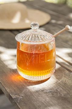 a glass jar filled with liquid sitting on top of a wooden table