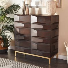 a wooden dresser with many drawers in a living room next to a potted plant