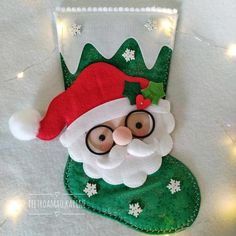 a christmas stocking made to look like santa claus with glasses and a green hat