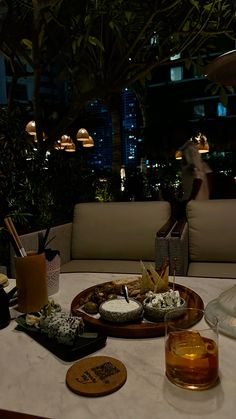 a table topped with lots of food on top of a white cloth covered dining room table