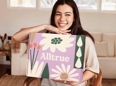 a woman holding up a box that says alttrue on the front and side