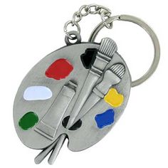 a silver key chain with a paintbrush and palette on it's center piece